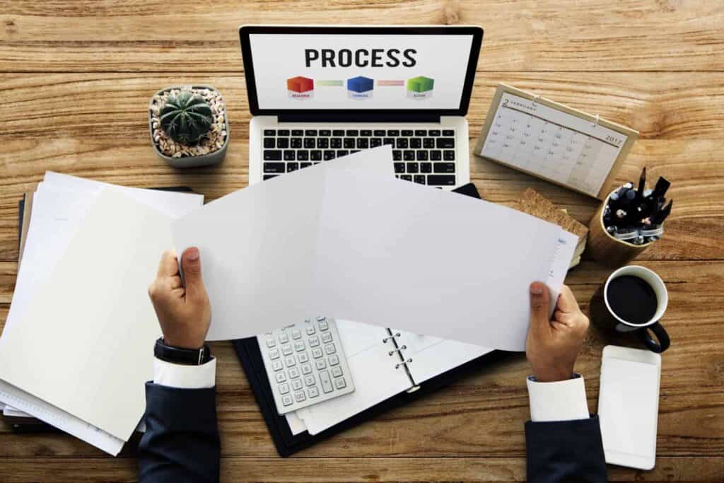 3 Thoughts About Hiring, Contracting, and Outsourcing 2 hands holding paper and working on laptop network LJQKUR7